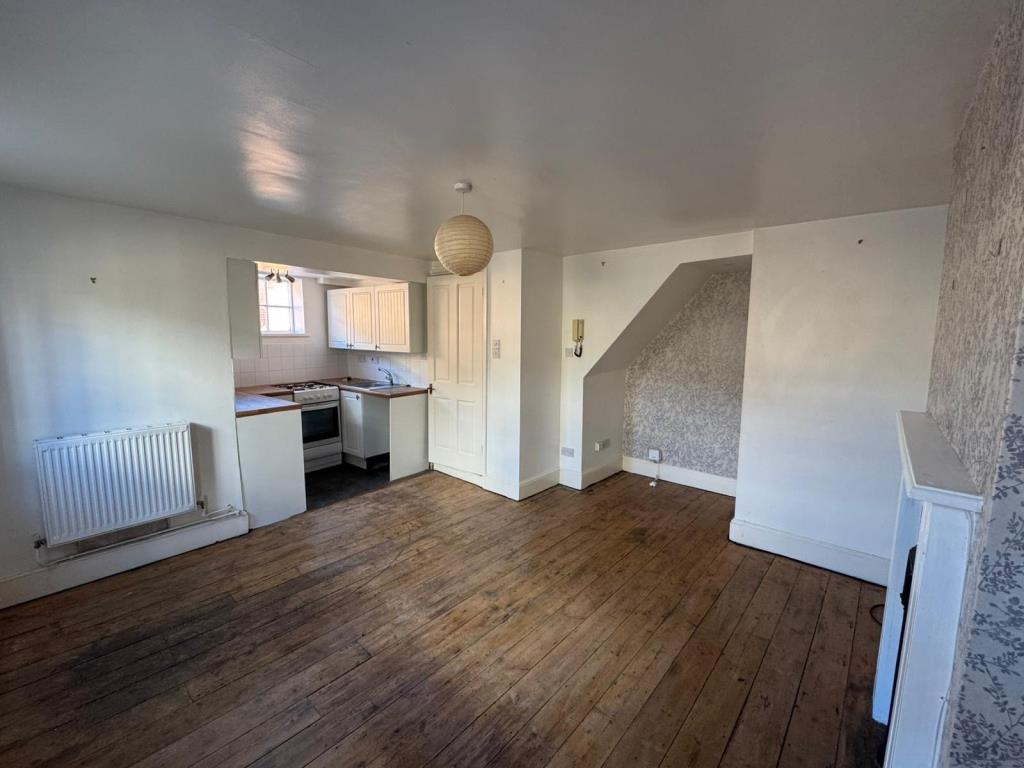 Lot: 183 - TOWN CENTRE MAISONETTE WITH GARDEN FOR INVESTMENT OR OCCUPATION - Living room and kitchen looking towards stairs